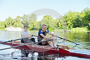 Team of two teenage boys kayaking on river