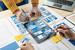 A team of UI UX web designers is working together to develop a mobile responsive website by previewing UI UX Front