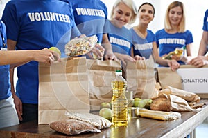 Team of volunteers collecting food donations at table