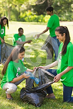 Team of volunteers picking up litter in park photo