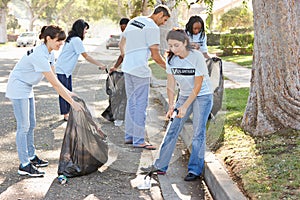Tím z dobrovoľníci vyberanie hore odpadky v predmestský ulice 