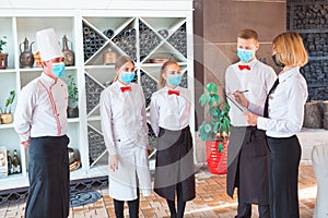 A team of waiters conduct a briefing on the summer terrace of the restaurant