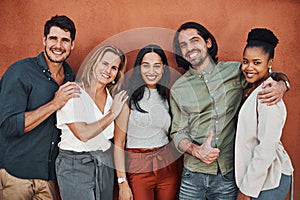 We are a team that wins. Cropped portrait of a diverse group of businesspeople standing together against a wall outside.