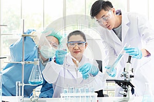 Team work asian woman and man Scientists analyzing virus data and evaluating microscope photo
