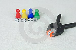 Team work concept - Figures in the line and an clamp tool as symbol for a working labor team collaboration photo