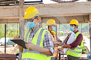 Team work construction engineers and three architects are ready to wear medical masks. Corona or Covid-19 wear masks at the