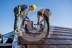 Team work construction worker install new ceramic tile roof in the construction site