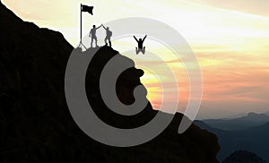 Team work, life goals and self improvement concept. Man helping his female climbing partner up a steep edge of a mountain