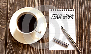 TEAM WORK - white paper with pen and coffee on wooden background