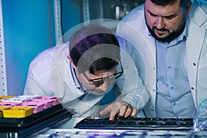 Team of Young Biologists People Analyzing Plants Seeds, Food Scientists Men Work in Agriculture Research Laboratory.