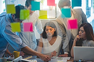 Team of young business employees collaborating on creating presentation at office photo