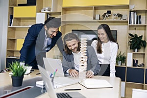 Team of young business people build a wooden construction