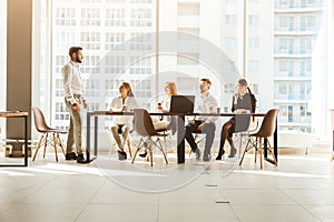 A team of young businessmen working and communicating together in an office. Corporate businessteam and manager in a