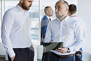 A team of young businessmen working and communicating together in an office. Corporate businessteam and manager in a