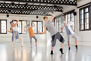 Team of young dancers training moves