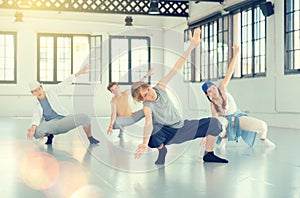 Team of young dancers training moves