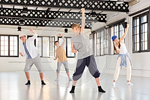 Team of young dancers training moves