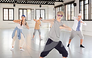 Team of young dancers training moves