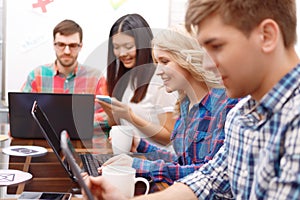 Team of young developers sitting at the table