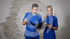 Team of young doctors wearing blue uniform looking at x-ray image in healthcare clinic. 4k