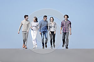 Team of young people walking along the road.outdoors