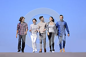 Team of young people walking along the road.outdoors