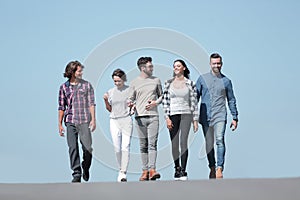 Team of young people walking along the road.outdoors