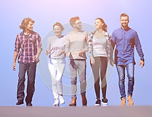 Team of young people walking along the road. outdoors