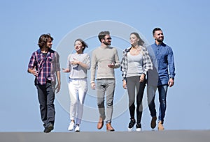 Team of young people walking along the road.outdoors