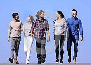 Team of young people walking along the road.outdoors