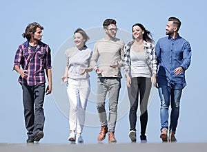 Team of young people walking along the road.outdoors