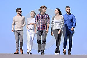 Team of young people walking along the road.outdoors