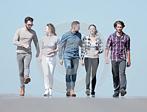 Team of young people walking along the road.outdoors