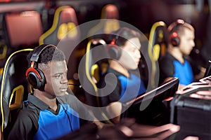 Team of young professional cybersport gamers wearing headphones participating in eSport tournament