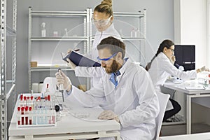 Team of young scientists doing research in a pharma or biotech science laboratory