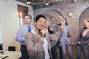 Teambuilding activity. Business people making team training exercise during team building seminar singing karaoke