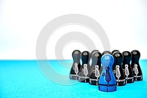 Teamleader with his team - with copyspace. Symbol for leadership with game figures in blue and black and drawn suit