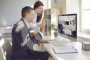 Teams of happy company workers from different departments having video conference