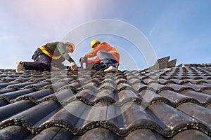 Teamwork of Asian roofer workers in protective uniform wear and gloves, using air or pneumatic nail gun and installing Concrete