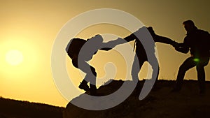 Teamwork of business people. Climbers silhouettes stretch their hands to each other, climbing to the top of hill