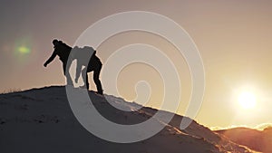 Teamwork business travel concept. two hikers gives hand winter snow tourists climbers climb to the top of the mountain