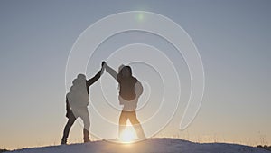 Teamwork business travel concept. two hikers gives hand winter snow tourists climbers climb to the top of the mountain