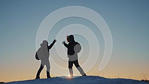 Teamwork business travel concept. two hikers gives hand winter snow tourists climbers climb to the top of the mountain