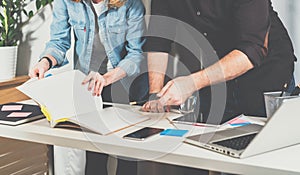 Teamwork. Businessman and businesswoman standing near table and leafed through a folder with documents