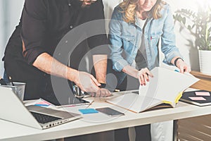 Teamwork. Businessman and businesswoman standing near table and look in directory information.