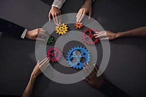 Business team connect pieces of gears. Teamwork, partnership and integration concept photo