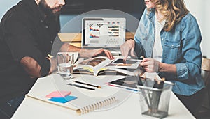 Teamwork. Businesswoman and businessman sitting at table and look in log data.On table is tablet computer