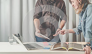Teamwork businesswoman standing and shows pencil on screen tablet computer in hands of businessman.