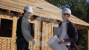 Teamwork. concept building constructing architect slow motion video. two men builder in helmets shake hands contract