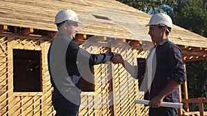 Teamwork. concept building constructing architect slow motion video. two men builder in helmets shake hands contract